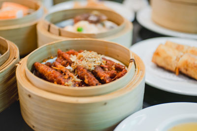 Close-up of dim sums served in steamers on table