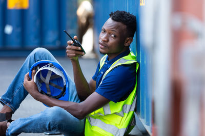 Portrait of young man holding walkie-talkie