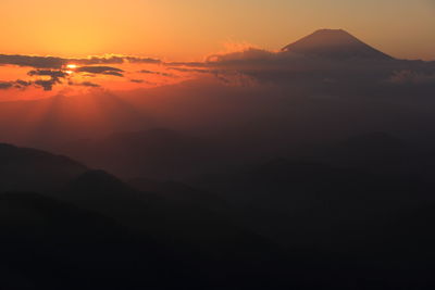 Scenic view of silhouette mountains against romantic sky at sunset