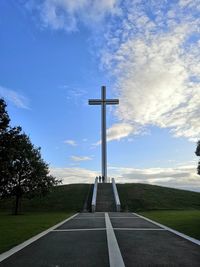 Cross amidst trees against sky