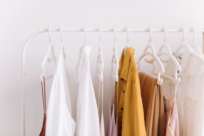 Clothes hanging on rack against white background