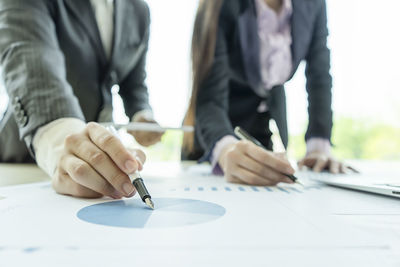 Close-up of people working on table