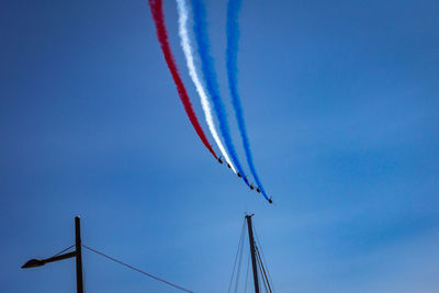 Low angle view of airplane flying against blue sky