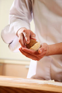 Midsection of chef preparing food at kitchen