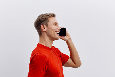 Portrait of young man standing against white background