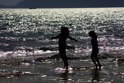 Silhouette of people in sea at sunset