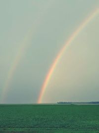 Scenic view of rainbow over sea against sky