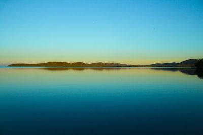 Scenic view of lake against clear blue sky