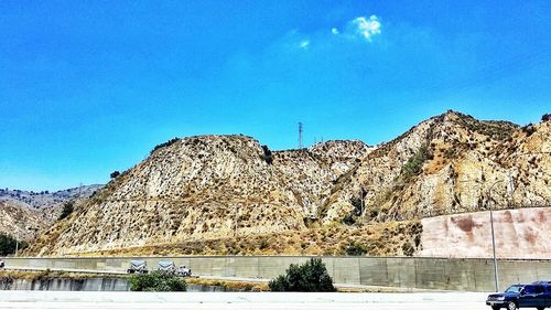 Low angle view of mountain range against blue sky