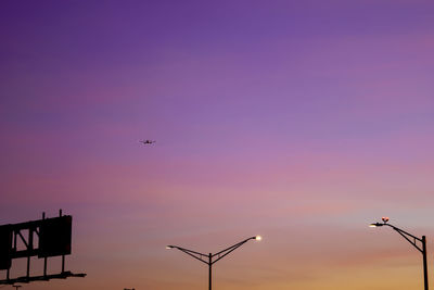 Low angle view of street lights against sky during sunset