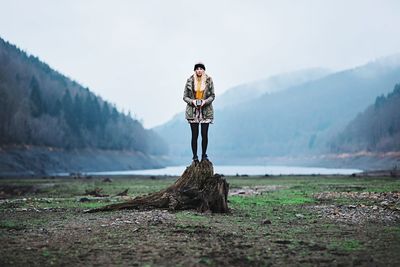 Rear view of woman standing on mountain landscape