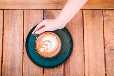 Directly above shot of hand holding coffee cup