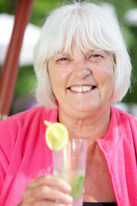 Close-up of smiling senior women holding cocktail glass