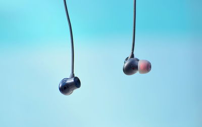 Close-up of electric lamps against blue sky