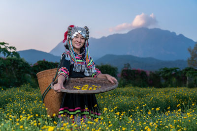 Full length of smiling woman standing on field