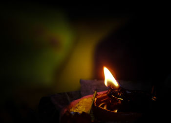 Close-up of lit candle in the dark