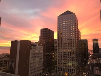 Modern buildings against sky during sunset
