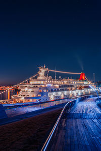 Illuminated bridge against sky at night