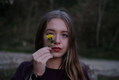 Girl looking at flower outdoors