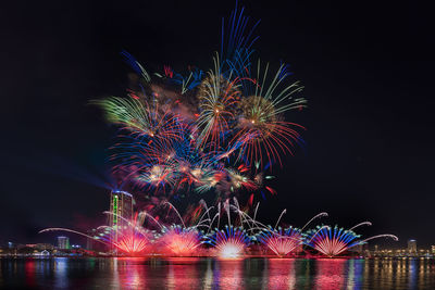 River against firework display at night