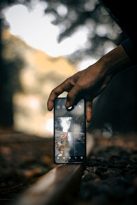 Midsection of person holding glass against sky