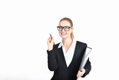 Smiling businesswoman looking away while holding file against white background