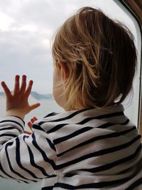 Close-up of child on hand against sky