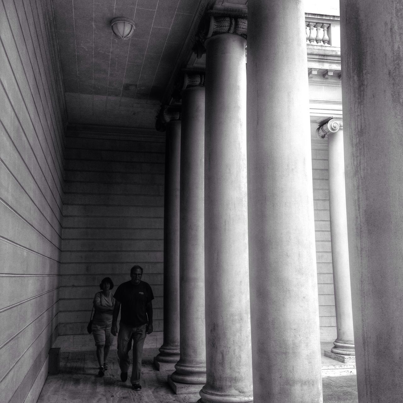 indoors, lifestyles, men, architecture, built structure, leisure activity, full length, rear view, person, architectural column, walking, history, standing, steps, column, corridor, togetherness