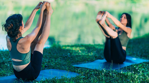 Yoga women by the water. boat pose