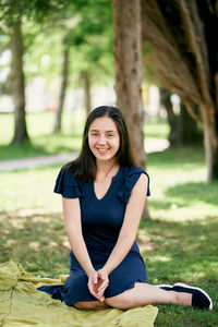 Portrait of smiling woman sitting at park