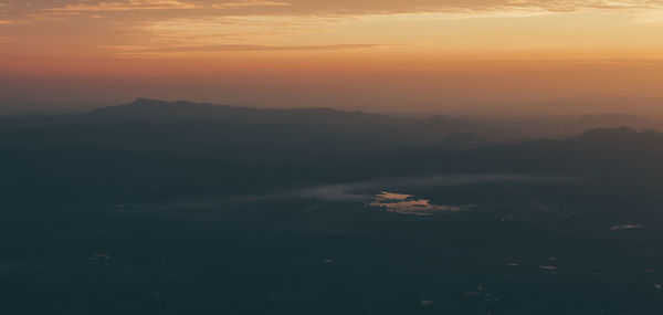 Scenic view of mountains against orange sky