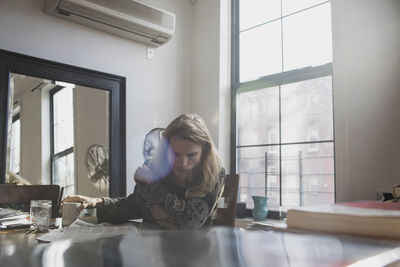 Woman sitting on table at home