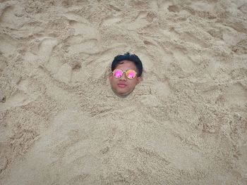 High angle portrait of man buried in sand