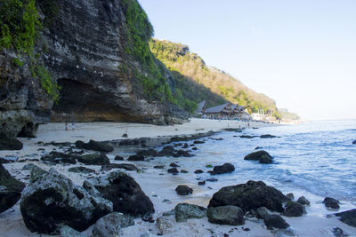 Scenic view of rocks on beach against sky