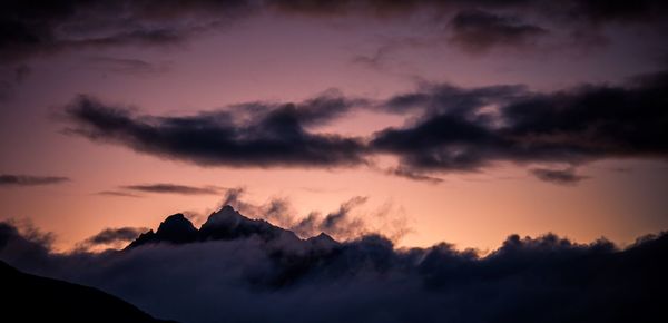 Silhouette of mountain against cloudy sky