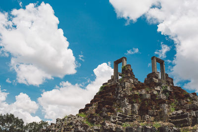 Low angle view of old building against cloudy sky