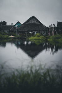 Scenic view of lake by buildings against sky