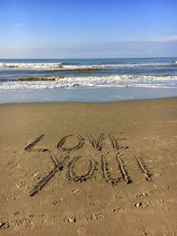 Scenic view of text on beach against sky