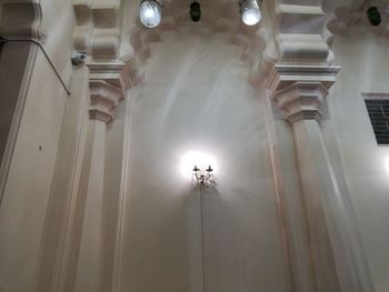 Low angle view of illuminated chandelier hanging on ceiling in building