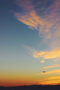 Airplane against sky during sunset