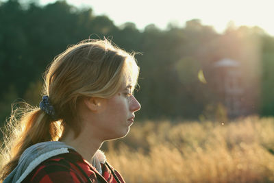 Side view of woman looking away on field