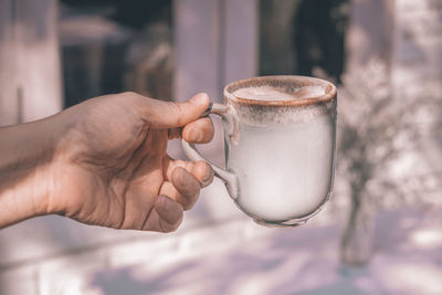 Close-up of hand holding drink coffee cup