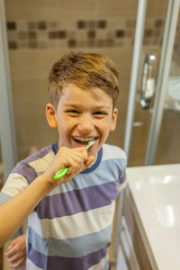 Close-up of boy brushing teeth at bathroom