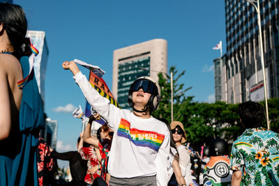 People standing in city against sky