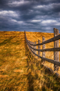 Old wooden fence in a autumn rural landscape with dark clouds, paltinis area, sibiu, romania, 1400m