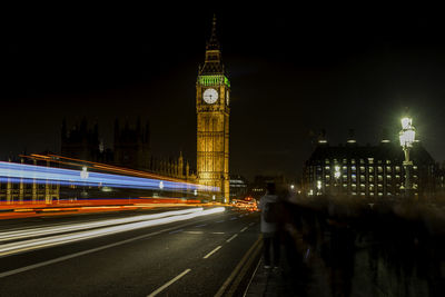 Light trails by big ben in city at night