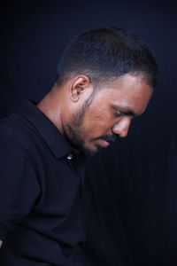 Portrait of young man against black background