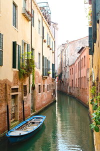 Boats in canal amidst buildings in city