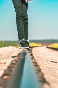 Low section of person standing on railroad track