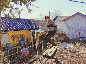 Man standing by house against building